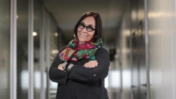 Professor Marisol de la Cadena crossing her arms, smiling. She is wearing a scarf and glasses. 