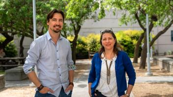 A photo of both Professors Marina Leiti and Jeremy Munday standing next to one another outdoors. Their hands are by their hips. 