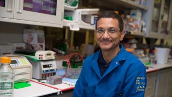 Professor Aldrin Gomes in his lab wearing a lab suit.