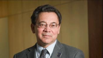 A headshot of former Dean Kevin Johnson. He is wearing a suit and glasses.