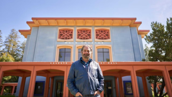 A photo of Professor Bogad in front of the theatre building on campus