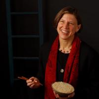 Professor Pamela Ronald holding a bowl of rice in her left hand and a pair of chopsticks in her right hand