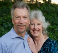 Karl Gerdes (on the left) and Pam Rohrich (on the right). Pam is learning on Karl, with her left hand on his chest. They are both smiling.